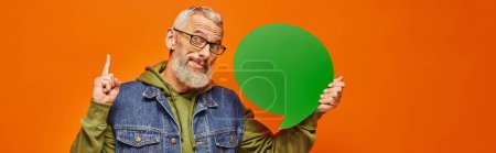 Photo for Attractive jolly mature man in stylish outfit holding speech bubble and looking at camera, banner - Royalty Free Image