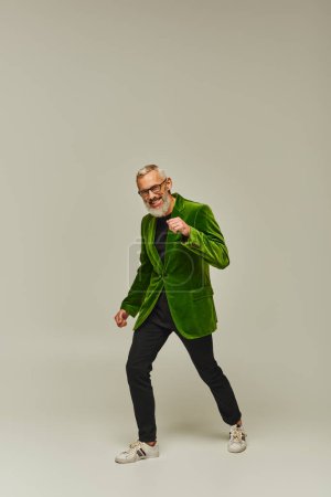 handsome funky mature man in green vibrant blazer with accessories smiling happily at camera