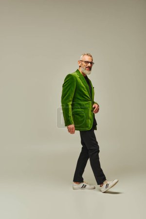 good looking jolly mature man in stylish vibrant clothes posing and smiling happily at camera