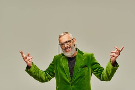 cheerful handsome mature male model in vibrant green blazer posing and smiling at camera happily