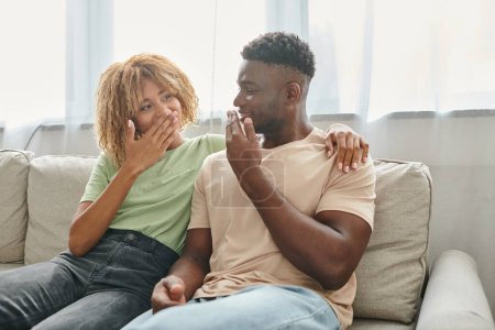 Foto de Feliz africano americano pareja comunicándose no verbalmente entre sí en casa, lenguaje de señas - Imagen libre de derechos