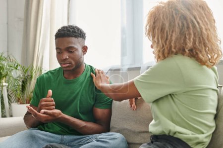 Schwarzer Mann zeigt Hilfsgeste, während er mit Freundin kommuniziert und Zeichensprache benutzt