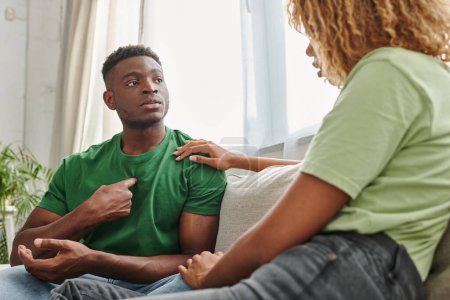 Schwarzer Mann zeigt auf sich selbst, während er mit Freundin kommuniziert und Zeichensprache benutzt