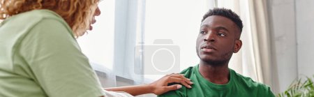 Photo for Black woman touching shoulder of concerned boyfriend while supporting him at home, banner - Royalty Free Image