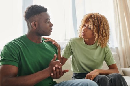 Schwarzer Mann zeigt Hilfsgeste, während er mit besorgter Freundin kommuniziert und Zeichensprache benutzt