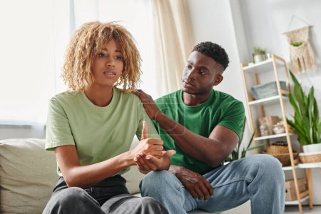 jeune homme afro-américain réconfortant petite amie dans les bretelles montrant signe d'aide, soutien émotionnel