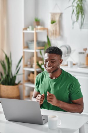 Photo for African american man smiling while using sign language during video call on laptop at home - Royalty Free Image