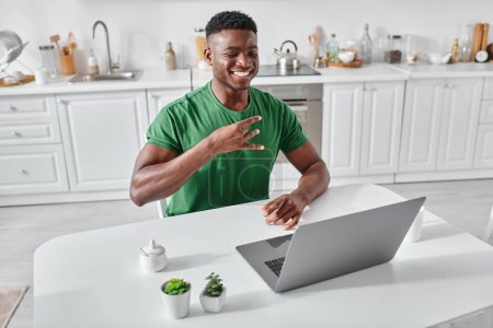 Photo for Happy deaf african american freelancer using sign language during video call on laptop at home - Royalty Free Image