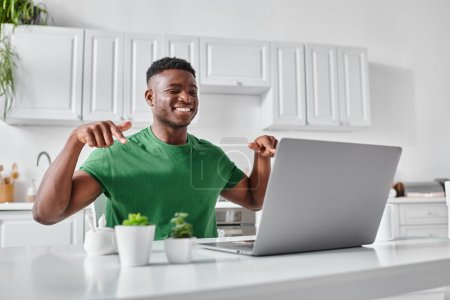 feliz sordo afroamericano freelancer utilizando lenguaje de señas durante la reunión en línea en el ordenador portátil