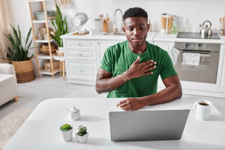 hombre afroamericano en camiseta verde usando lenguaje de señas para la comunicación en línea, gesto de mano