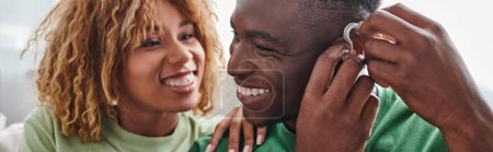 sourd et heureux homme afro-américain portant prothèse auditive près de petite amie, bannière de dispositif de santé