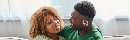 pancarta de la feliz pareja afroamericana abrazando, hombre negro sordo en audífono y mujer en aparatos ortopédicos