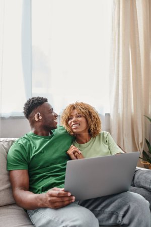 heureux couple afro-américain marche film sur ordinateur portable, sourd homme dans l'air de l'ouïe et de la femme