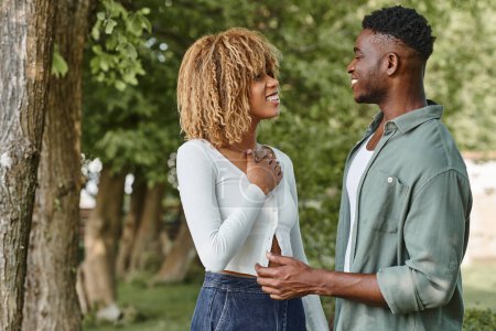Téléchargez les photos : Langage des signes, heureux couple afro-américain tenant la main et communiquant avec des gestes à l'extérieur - en image libre de droit