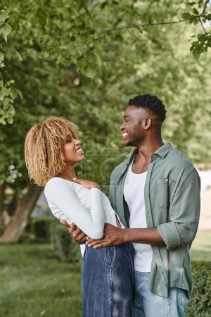 Photo for African american couple laughing and hugging each other outdoors, black woman in braces and man - Royalty Free Image