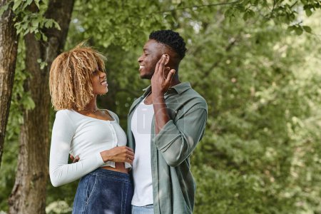 Téléchargez les photos : Langage des signes, heureux couple afro-américain communiquant avec des gestes et debout à l'extérieur - en image libre de droit