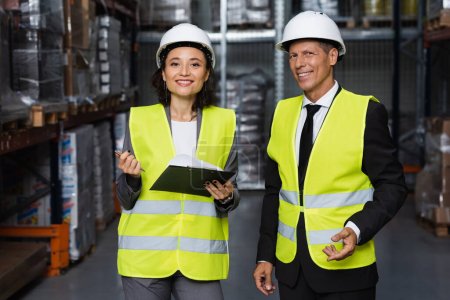 Photo for Professional headshot, middle aged supervisor and female employee in hard hat with clipboard - Royalty Free Image
