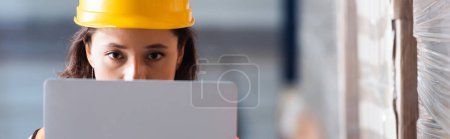 Photo for Focused female logistics worker with laptop looking at camera, stock control and cargo check banner - Royalty Free Image