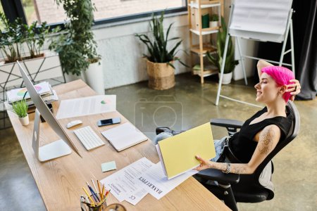 kurzhaarige tätowierte Geschäftsfrau arbeitet am Schreibtisch mit Dokument mit dem Wort Konkurs darauf