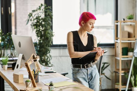 Téléchargez les photos : Attrayant cheveux courts travailleuse prenant des notes à côté de son bureau avec des gadgets, concept d'entreprise - en image libre de droit