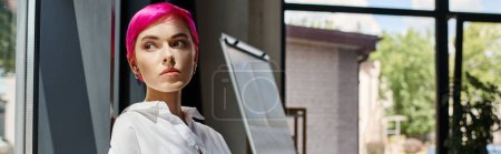 pensive attractive businesswoman in casual office attire posing and looking away near window, banner
