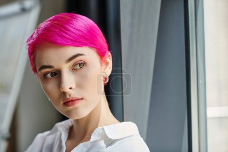 attractive short haired businesswoman in casual white shirt posing at office and looking away