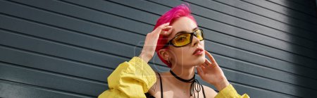 Téléchargez les photos : Élégante femme chic avec des cheveux roses et tatouage posant dans des lunettes de soleil et streetwear à la mode, bannière - en image libre de droit