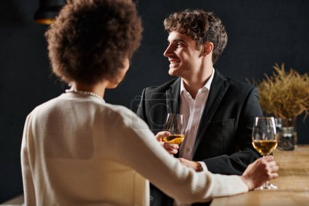 focus on handsome man smiling while having a great time during date with girlfriend on valentines day