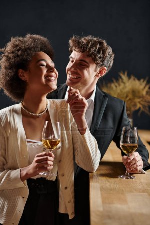 glücklicher Mann, der lächelt und seine afrikanisch-amerikanische Freundin beim Date am Valentinstag ansieht, Romantik