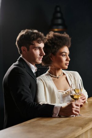 schönes multikulturelles Paar mit Gläsern Weißwein beim Date am Valentinstag