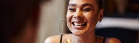 heureuse femme afro-américaine souriant sincèrement pendant la date de la Saint-Valentin, bannière de dîner romantique