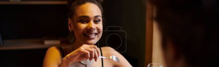 banner of african american woman smiling and looking at man during dinner date on Valentines day