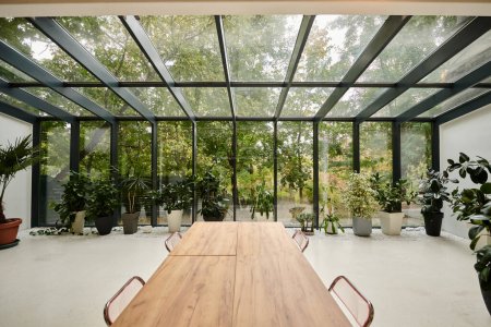 Innenaufnahme eines modernen stilvollen Konferenzraums mit Bürotisch und grünen lebenden Pflanzen in Töpfen