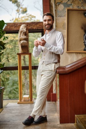 cheerful attractive business leader with beard with elegant dapper style drinking his coffee