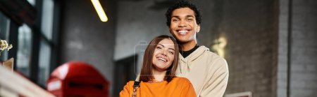 Satisfied diverse couple in casual attire embracing beside a counter of hostel near luggage, banner