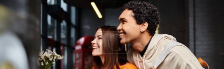 african american man and happy woman smiling and looking away in hostel, romantic getaway banner