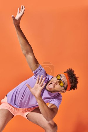 scared african american sportsman in gym attire gesturing and screaming on orange background