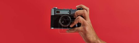Téléchargez les photos : Bannière recadrée du photographe afro-américain prenant des photos sur caméra rétro sur fond rouge - en image libre de droit