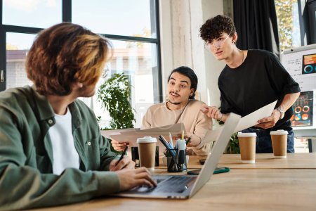 Photo for Team of young entrepreneurs engaged in project planning at a bright office, blurred man near laptop - Royalty Free Image