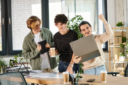 Drei junge Männer in einer lebhaften Diskussion über einen Laptop in einem Coworking Space, Erfolg
