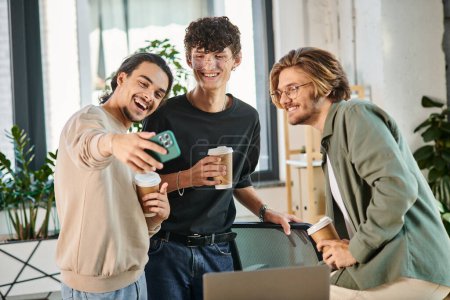 Young businessmen enjoying a coffee break and taking a selfie in a coworking space, men in 20s