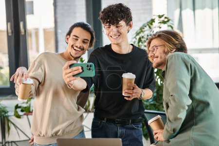 happy businessmen enjoying a coffee break and taking a selfie in a coworking space, men in 20s