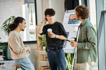 young coworkers in their 20s sharing ideas and holding coffee to go in modern office, startup team