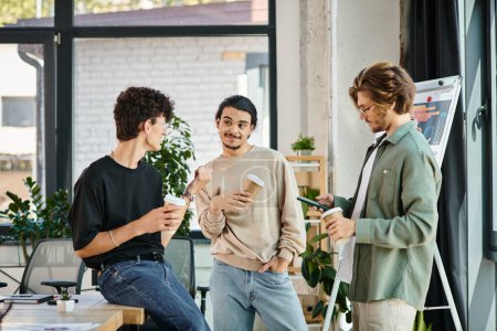 jeunes hommes dans la vingtaine partageant des idées et bavardant autour d'un café pour aller dans un bureau moderne, équipe de démarrage