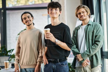 Three young men in their 20s with coffee in a friendly office atmosphere, professional headshot