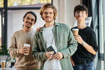 Three young men in their 20s with coffee in a friendly office atmosphere, professional headshot