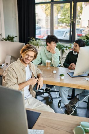 Photo for Happy creative team intensely focused on post-production work in a modern office, men in 20s - Royalty Free Image