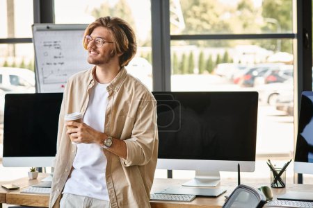 Téléchargez les photos : Homme souriant avec des lunettes tenant du café dans une configuration de bureau moderne, retouche de l'équipe de post-production - en image libre de droit