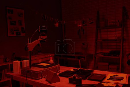interior cuarto oscuro con luz roja, mostrando el proceso de desarrollo del cine y el arte de la fotografía