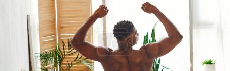 Photo for Back view of muscular shirtless african american man stretching in modern bedroom, horizontal banner - Royalty Free Image